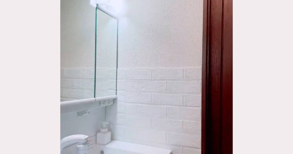 洗面台脇の壁にダイソークッションシートを貼りDIY完成した画像。