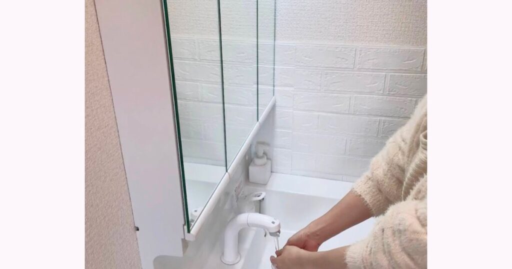 タイルシートが貼られた洗面台で水ハネを気にすることなく手を洗っている様子。