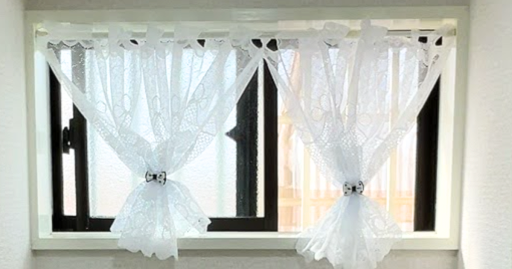 レースのカーテンに黒の水玉のヘアーゴムをタッセルの代わりに使いスッキリとした印象になった窓