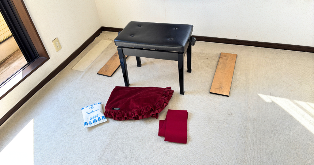 ぴながなくなった跡に残された、椅子、ピアノカバー、鍵盤カバー、ピアノの下に敷いてあった板