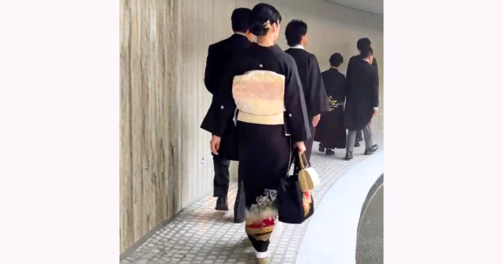 結婚式当日の朝、美容室での着付けを終え、黒留袖姿で家族と会場へ向かう後ろ姿